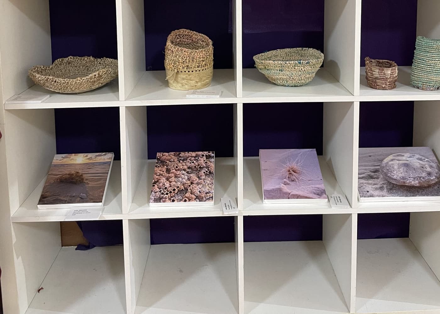 Cube shelving filled with coiled baskets and small vessels