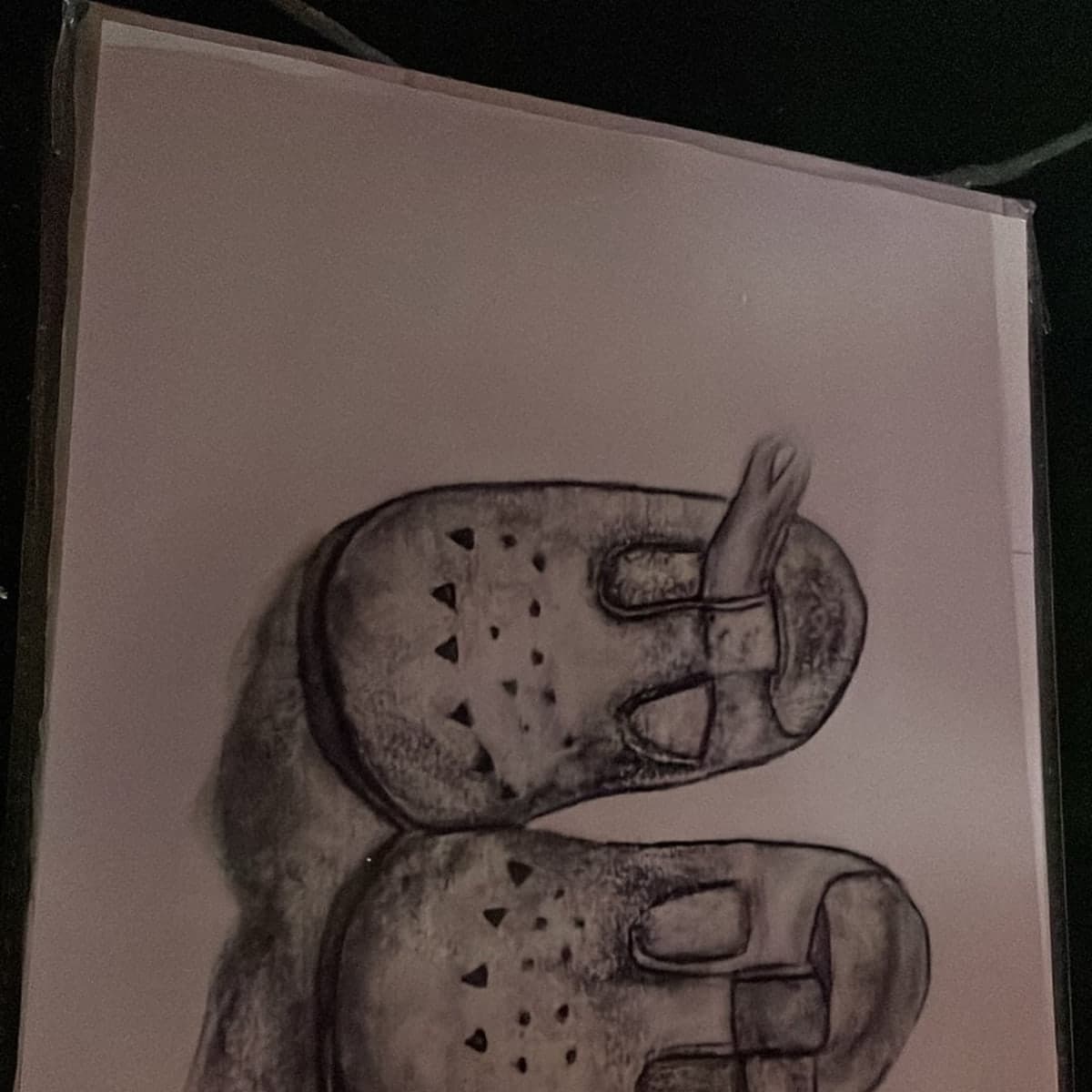 Cyanotype of a pair of infant shoes, drawn in white against deep Prussian blue