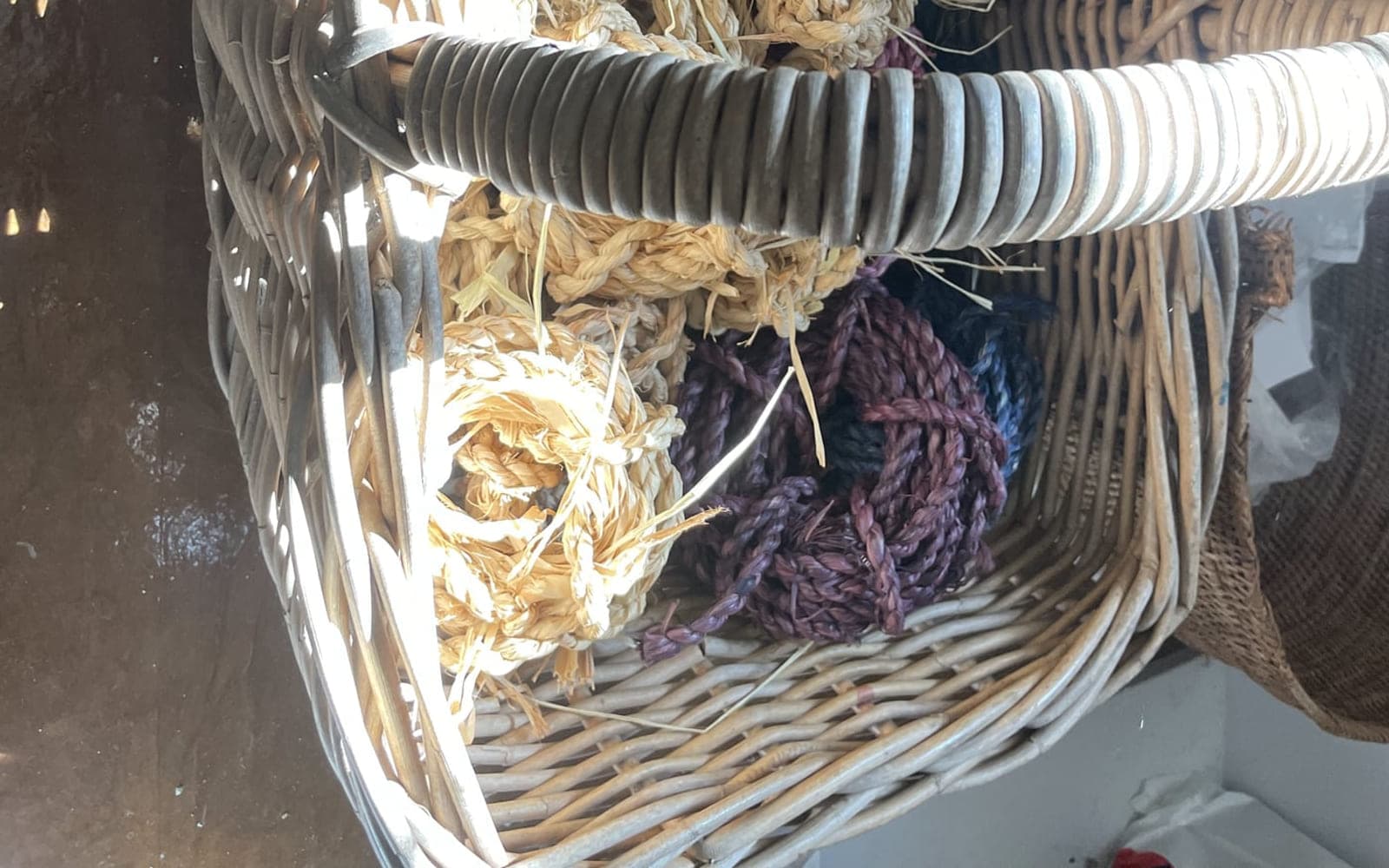 A basket of dried fibre and raffia bundles