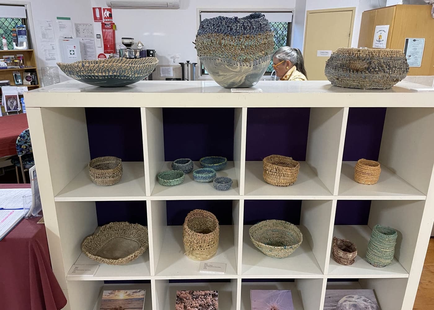 Gallery display shelves holding coiled baskets and bowls